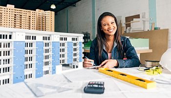 SEO 8 Architect smiling while working on building models and blueprints